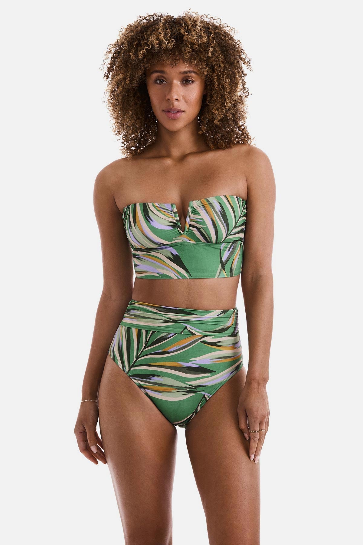 Woman wearing a multicolored leaf print bandeau midkini swim top with matching swim bottoms