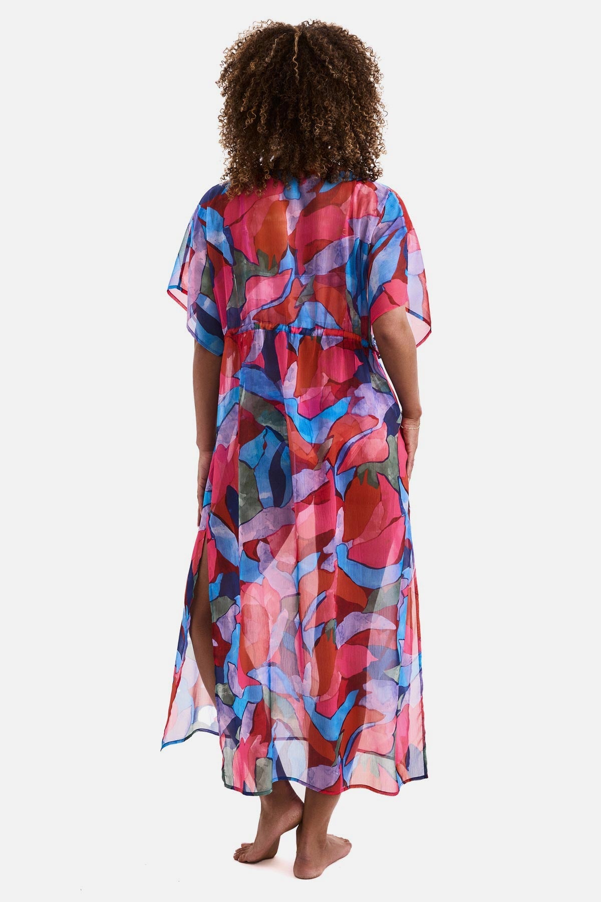 Woman turned away wearing a multicolored abstract printed sheer swim cover up