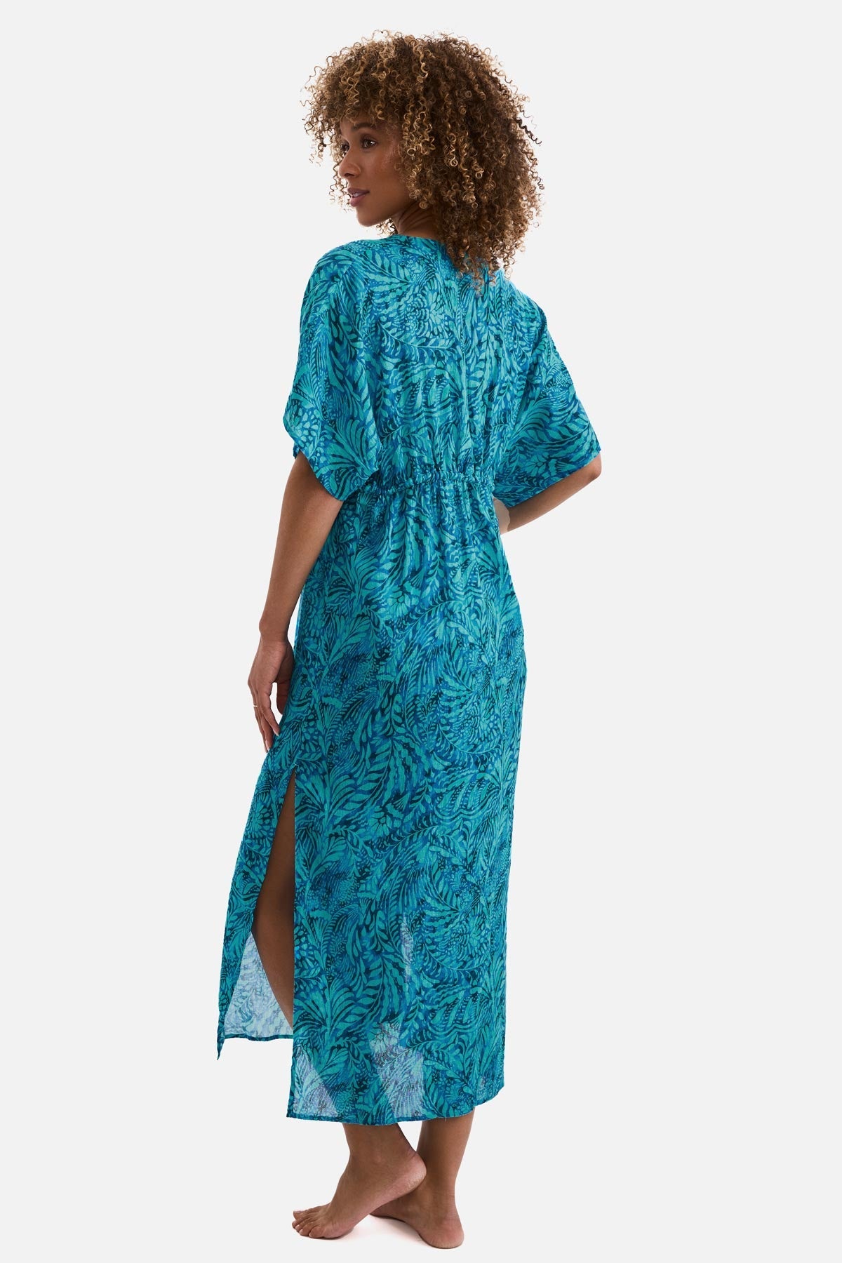 Woman turned left wearing a blue abstract printed caftan swim cover up