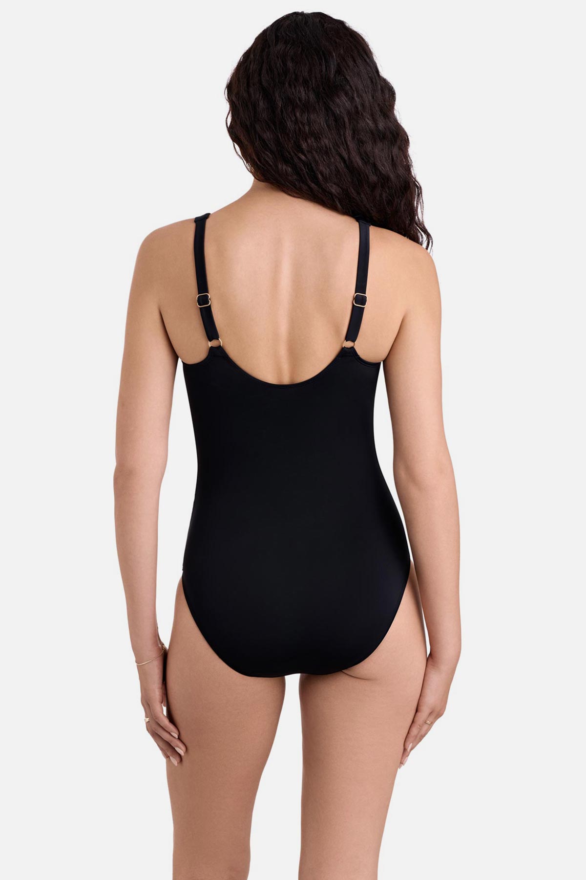 Woman turned away wearing a black one-piece swimsuit with ruffles on the neckline