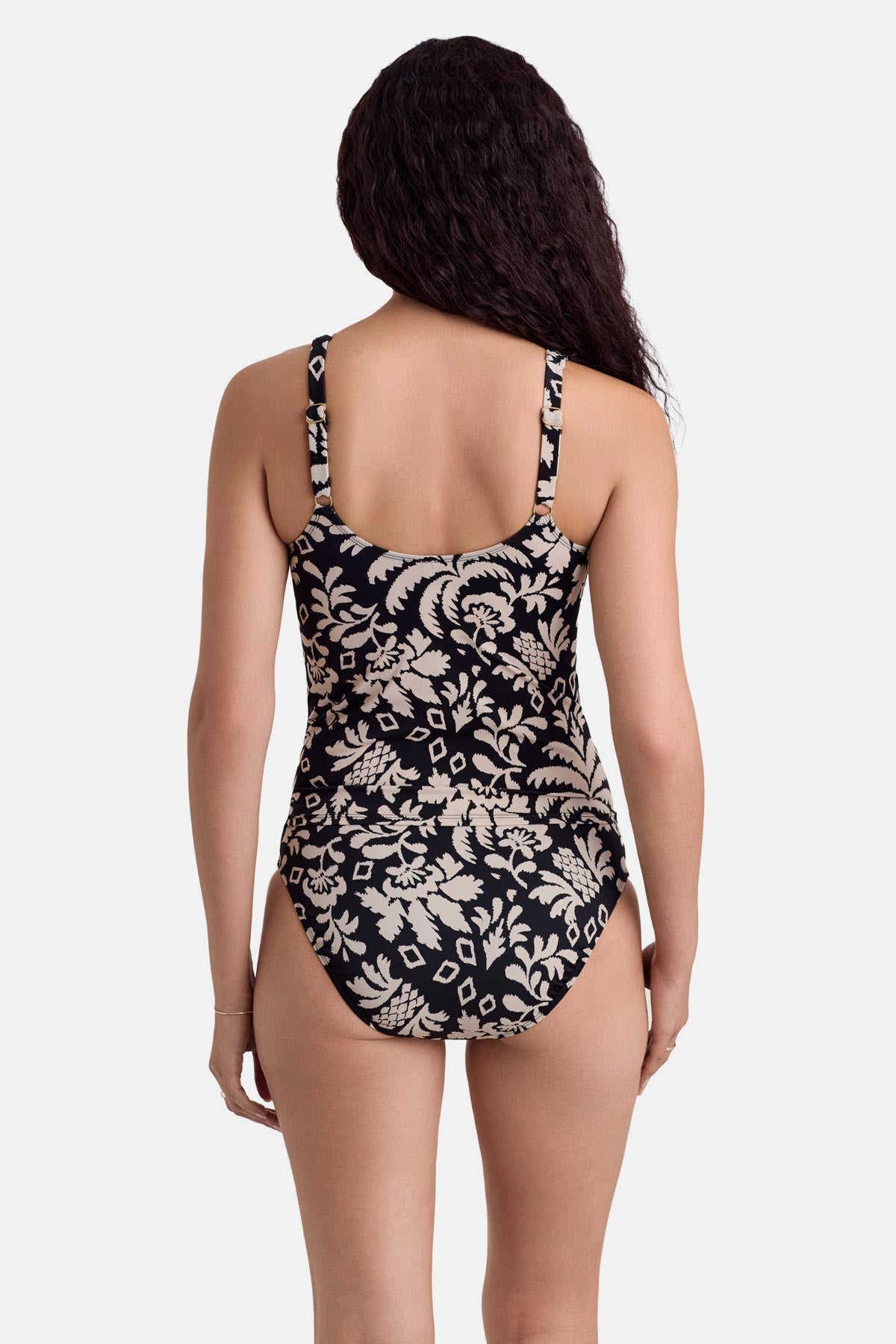 Woman turned away wearing a black and white palm tree printed tankini top